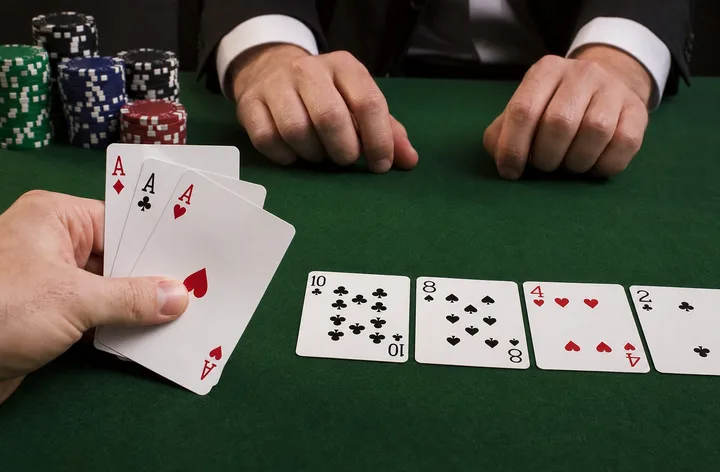 Three aces displayed as the highest Teen Patti Trail hand on maroon felt with gold chips